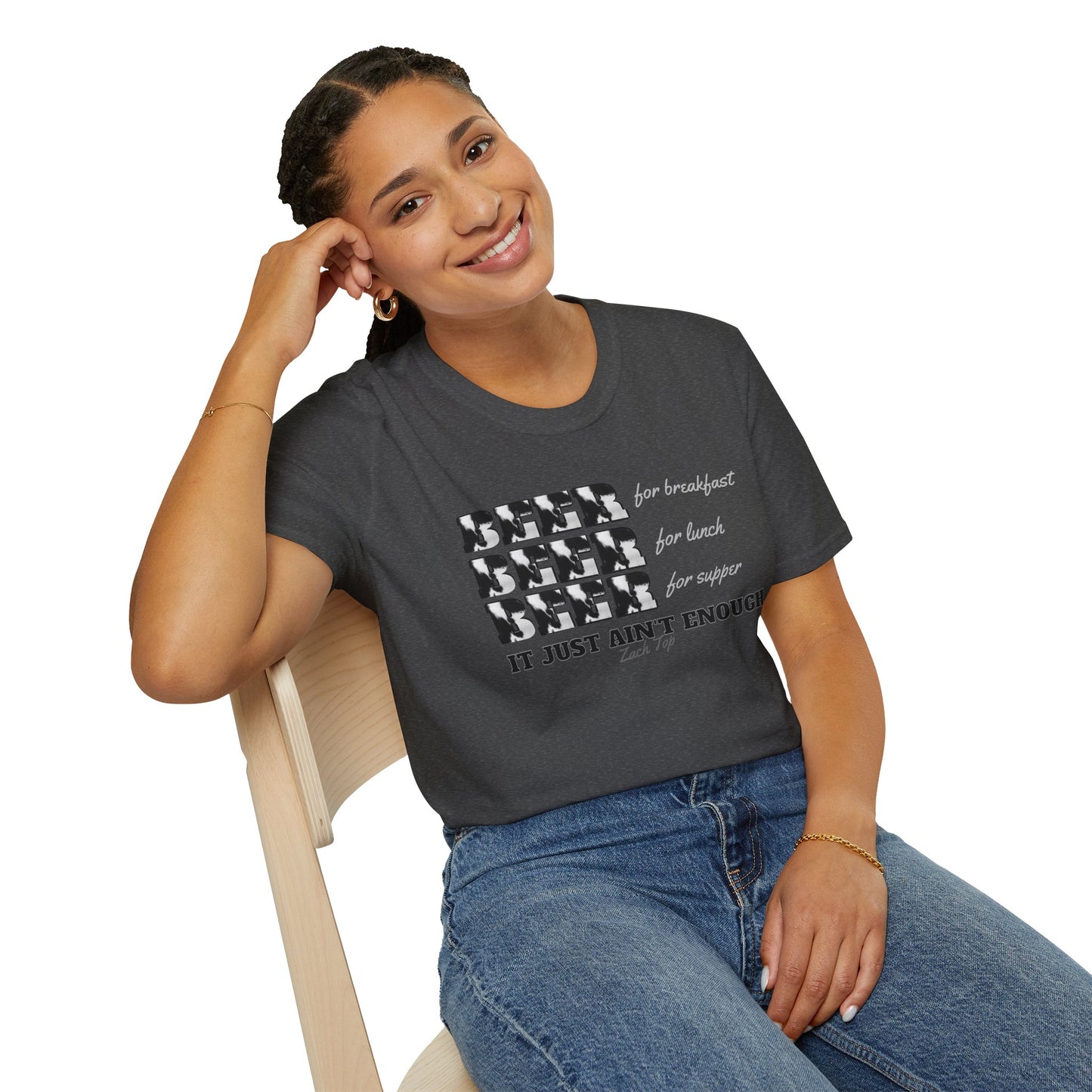 The front of the shirt displays the word "BEER" three times, each with a unique cow-print pattern, followed by the phrases "for breakfast," "for lunch," and "for supper" in a playful, cursive font. Below these, the shirt proudly declares, "IT JUST AIN'T ENOUGH,"