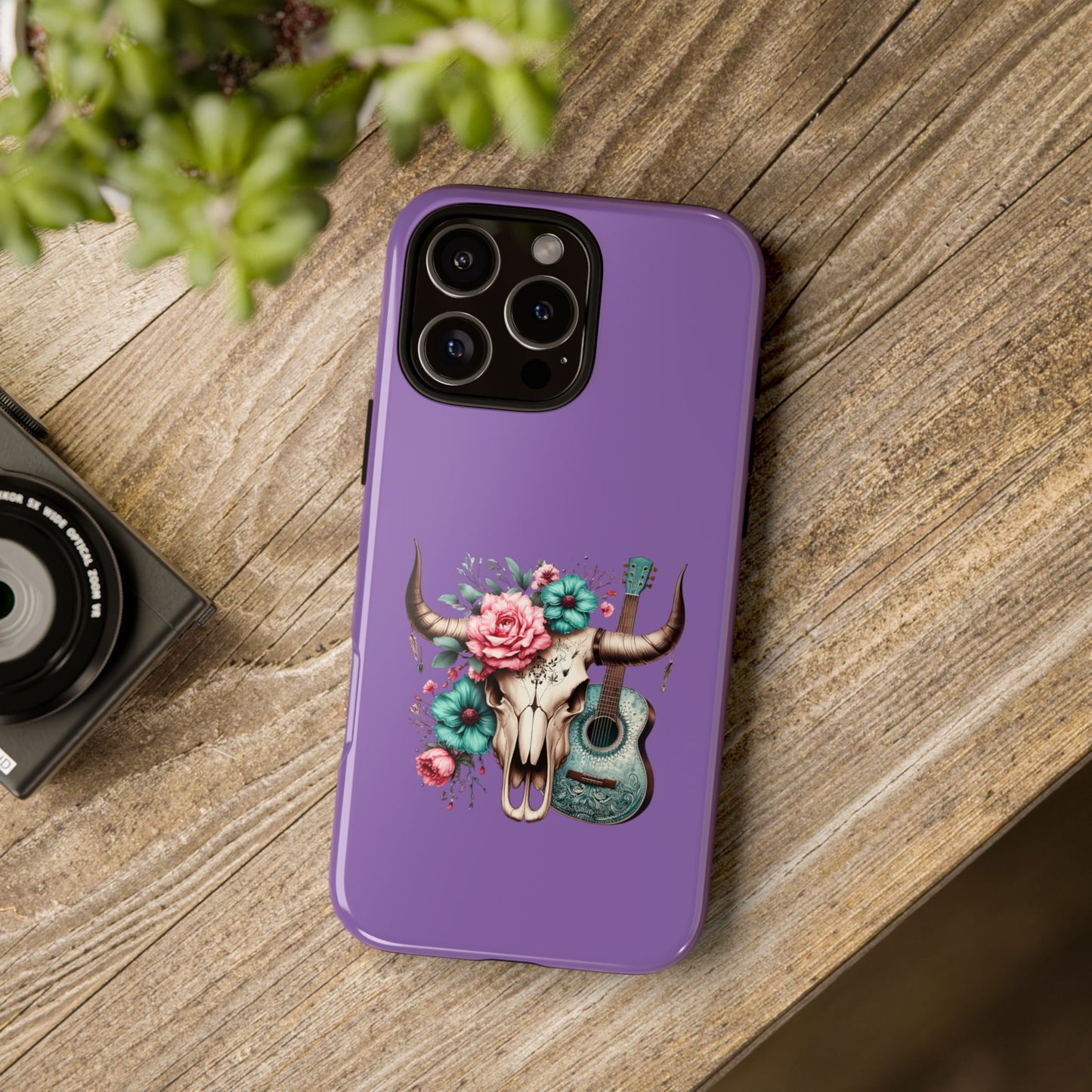 This case showcases a finely detailed bull skull adorned with intricate floral motifs, surrounded by stunning pink and teal blooms. The horns of the skull are elegantly embellished with jewelry, while a turquoise acoustic guitar with ornate designs