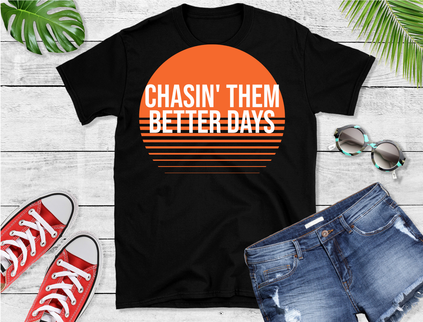 This stylish tee features a vibrant orange sunset graphic with bold white text that reads "CHASIN' THEM BETTER DAYS."