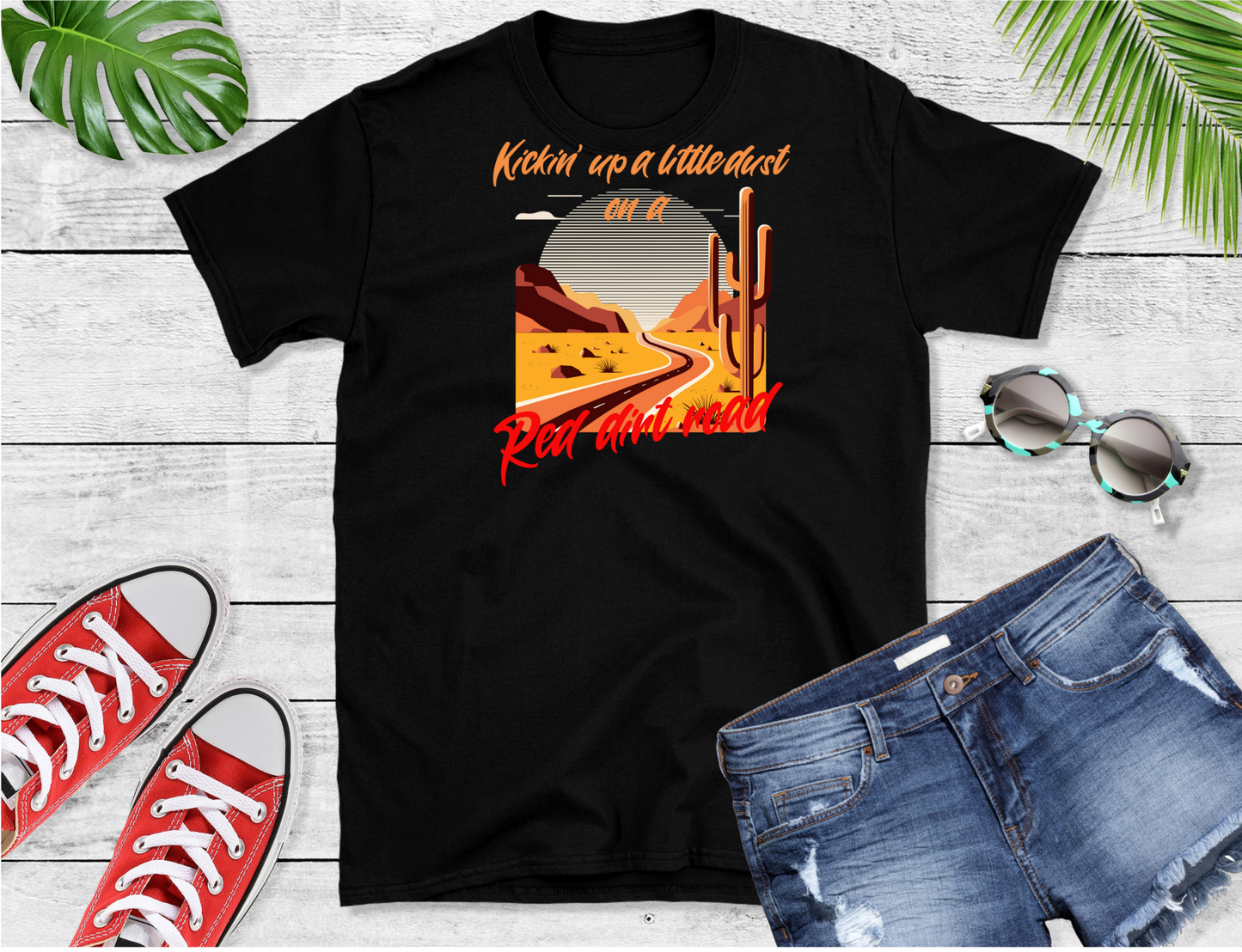 Image of a road winding through a desert with orange text above "Kickin' up a little dust on a" and in red text below "Red dirt road".