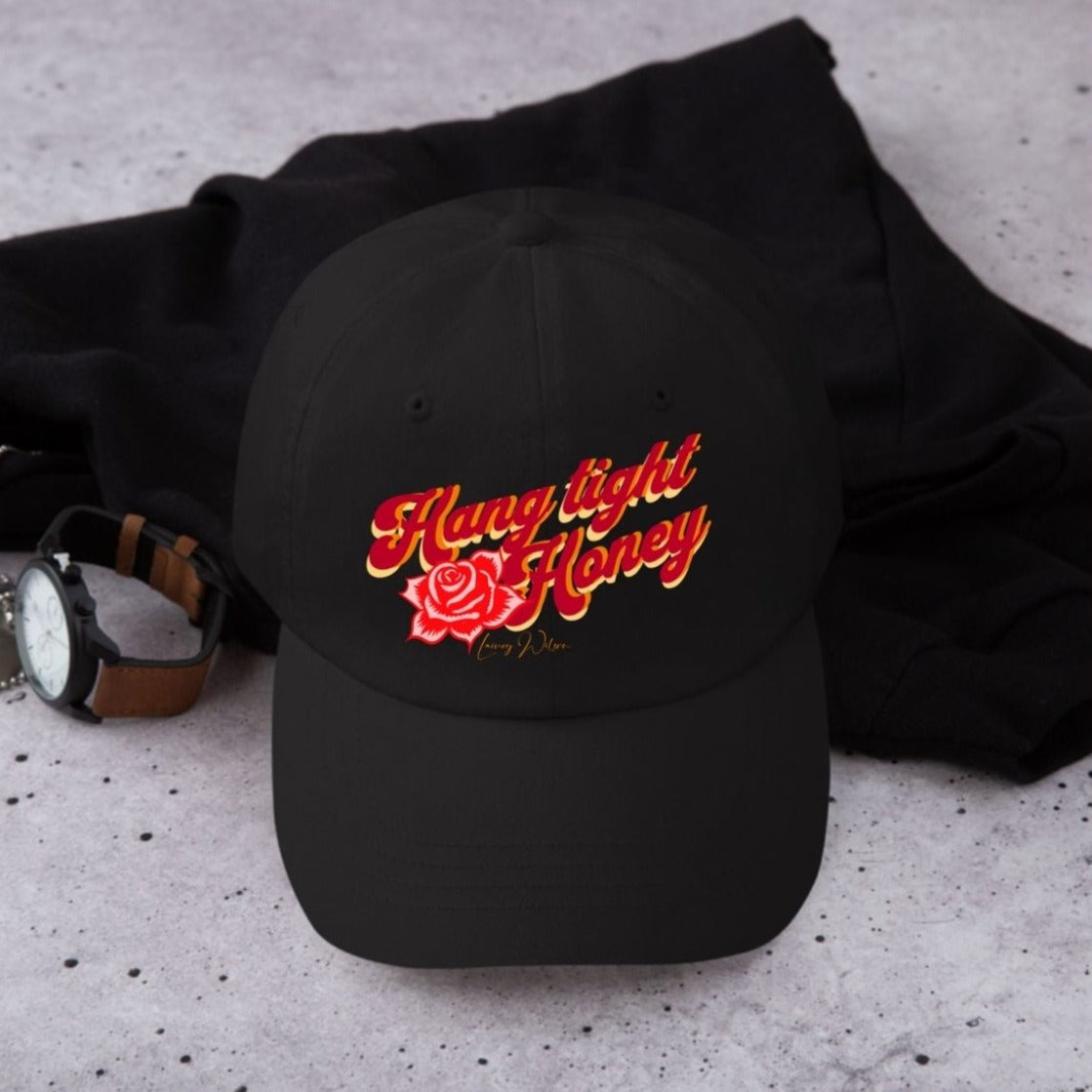 Balck cap with red, orange and yellow wording "hang tight honey" written on it