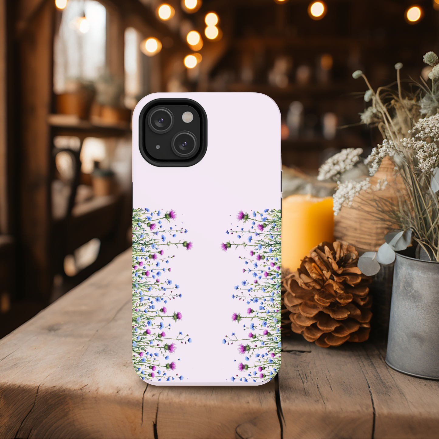 This case showcases an elegant arrangement of vibrant purple thistles and delicate blue flowers, set against a soft pastel pink background.