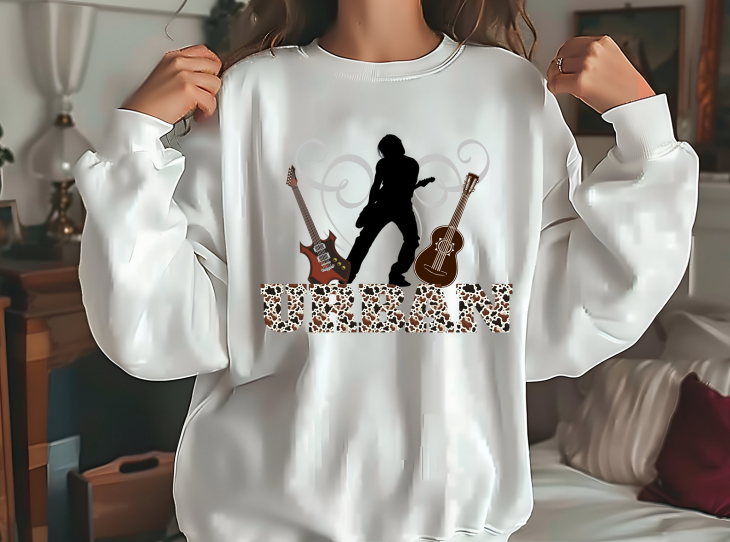 Featuring a bold silhouette of a guitar player in action, this design captures the essence of Keith Urban’s dynamic stage presence. Flanked by two intricately detailed guitars, one electric and one acoustic, it pays homage to Urban’s versatility as an artist. The word “URBAN” is emblazoned across the bottom in a striking font filled with a leopard print pattern
