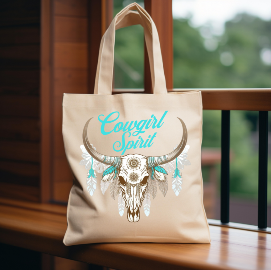 The bold design showcases a beautifully detailed longhorn skull adorned with delicate mandala patterns, surrounded by soft, flowing feathers in earthy and turquoise tones.