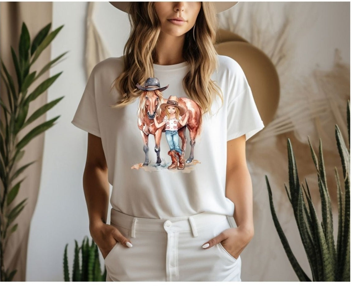 Lady standing in a room with the cowgirl with the horse design on a white t-shirt