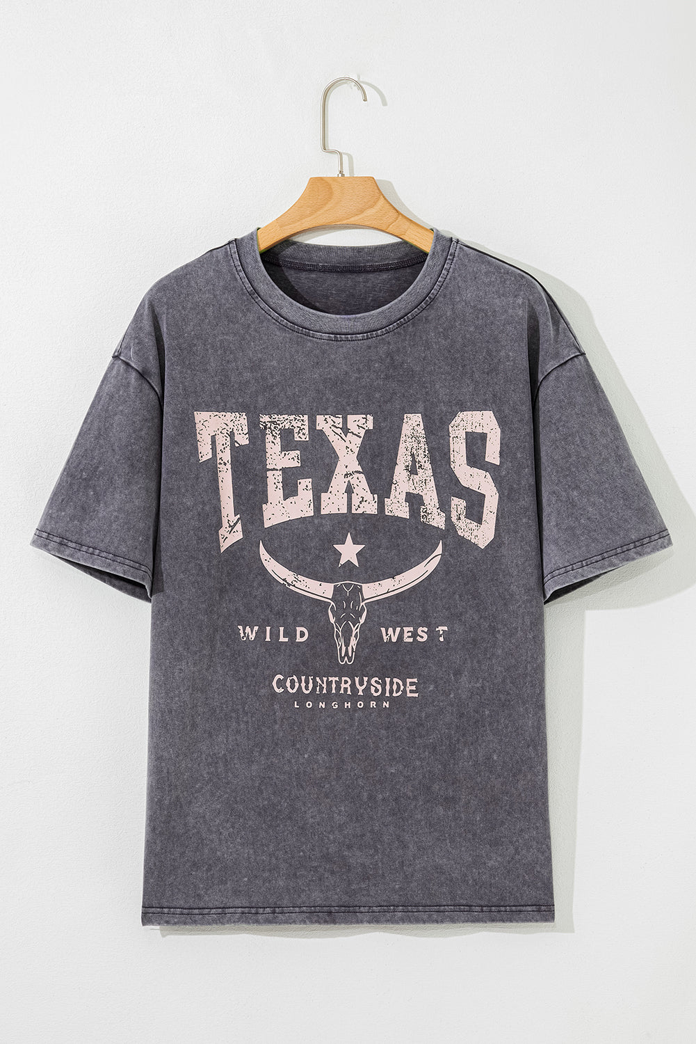 Gray t-shirt with 'Texas Wild West Countryside London' print on a wooden hanger against a white background