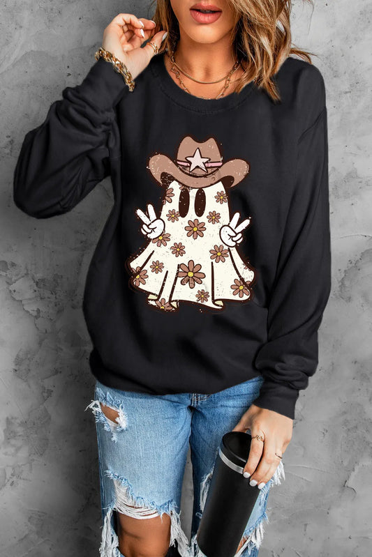Person wearing a black sweatshirt with a graphic design, holding a tumbler against a gray background