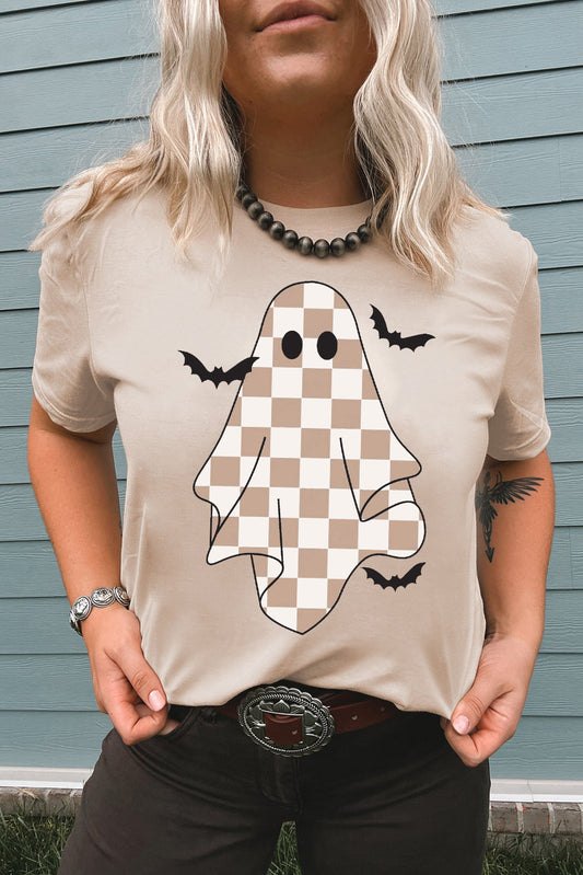 Person wearing a beige t-shirt with a checkered ghost design outdoors.