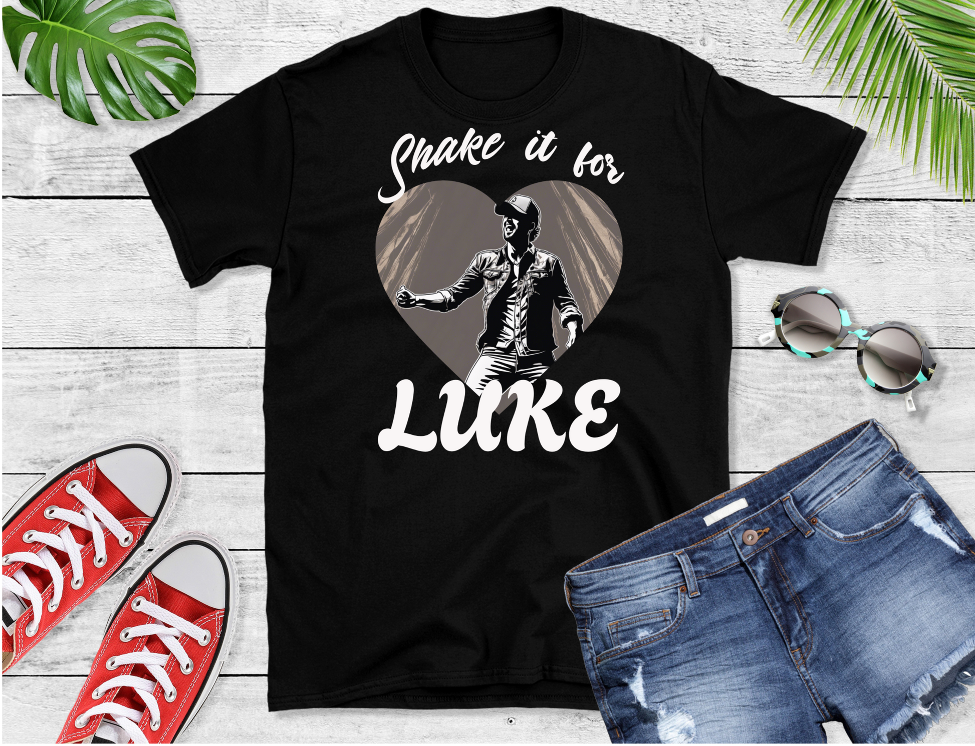 Featuring a striking monochromatic graphic of Luke mid-performance, this design showcases him set against a heart-shaped background. The bold text “Shake it for” above and “LUKE” below the figure 
