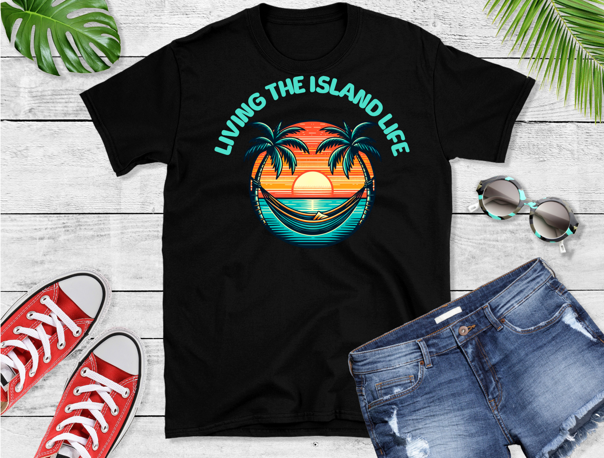 Featuring a serene design with palm trees swaying against a backdrop of warm sunset hues blending into cool ocean blues, this t-shirt captures the essence of island living. The phrase “LIVING THE ISLAND LIFE” is prominently displayed above.