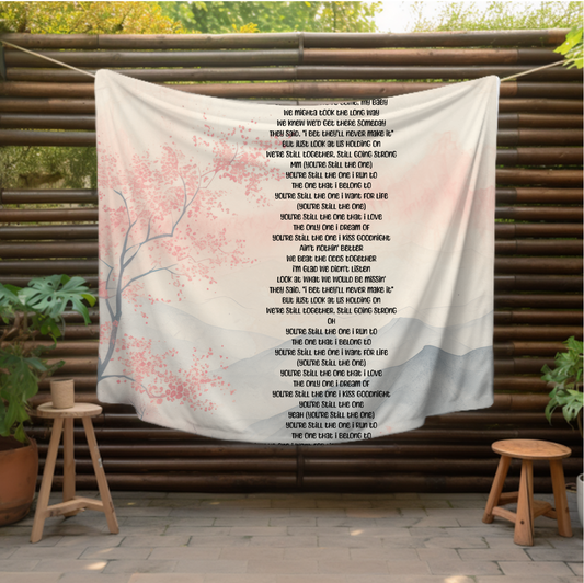 features the heartfelt lyrics of You're Still The One elegantly printed over a serene, pastel background of cherry blossoms and misty mountai