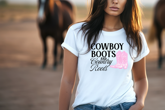 Features a bold graphic design with the text “COWBOY BOOTS” in large, eye-catching font, and “AND COUNTRY ROOTS” below it. The highlight of the design is a pair of pink cowboy boots adorned with intricate white stitching and star patterns