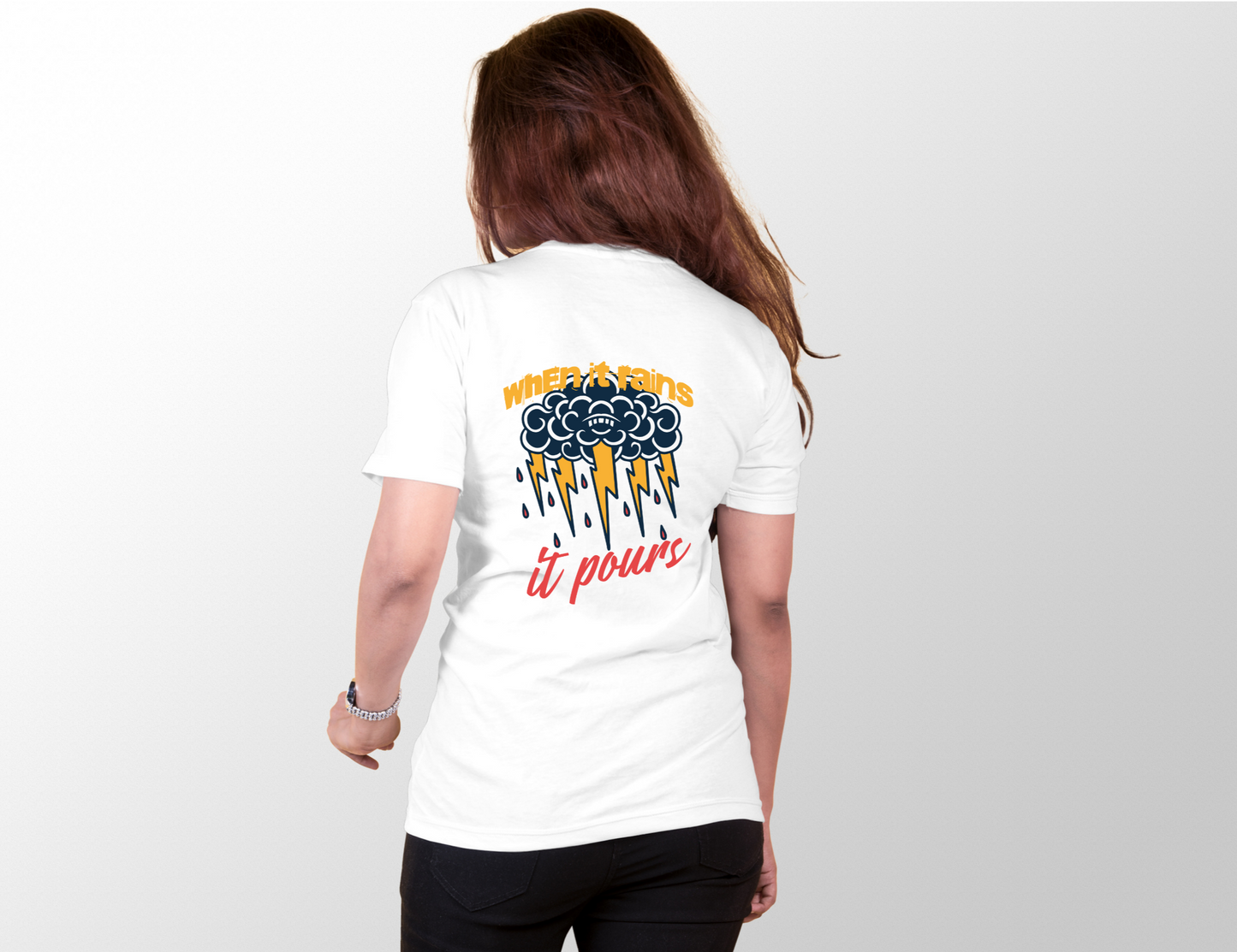 Features a bold graphic of a dark, stylized cloud with expressive, swirling patterns and a subtle face in the center. From the cloud, vibrant yellow lightning bolts strike down, interspersed with red raindrops, creating a dynamic and energetic visual effect.  The phrase "when it rains" is written above the cloud in a bold, yellow font, while "it pours" is displayed below the lightning bolts in a flowing, red script.