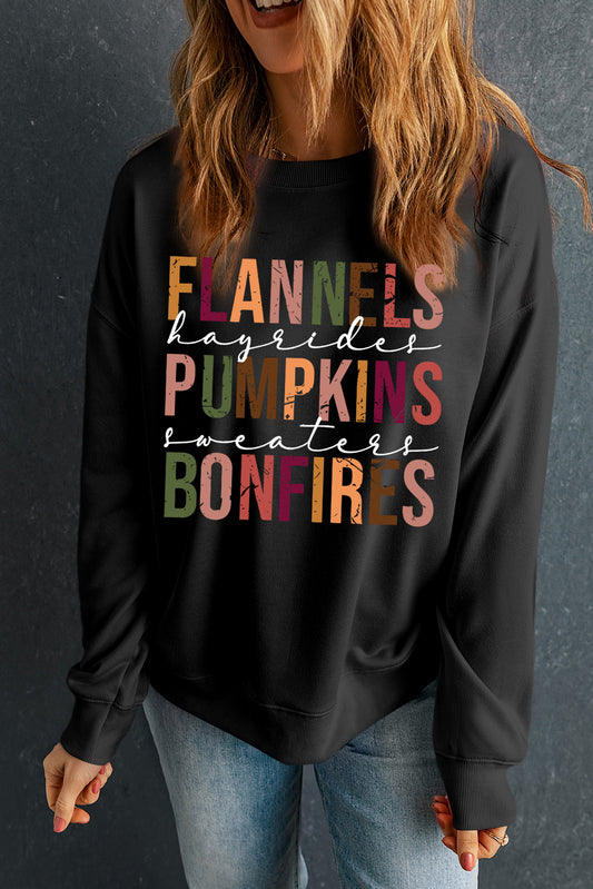 Person wearing a black sweatshirt with colorful text on a dark background